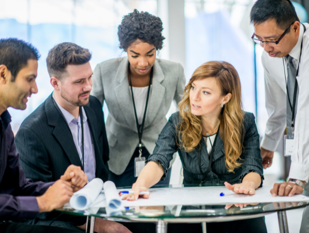building-strong-in-house-legal-team A diverse in-house legal team collaborating in a corporate office, symbolizing strengths-based teamwork and leadership.