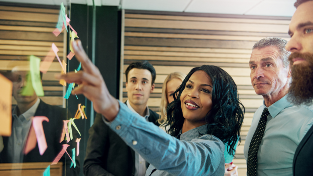 AI Is a Team Sport—And Legal Needs to Be on the Field A diverse group of professionals collaborating around a table, symbolizing cross-functional teamwork in AI development.