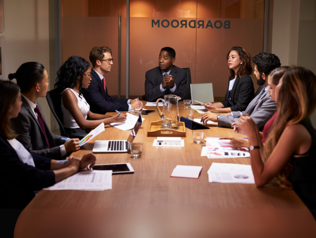 confident_lawyer_boardroom Boardroom readiness for in house counsel: A confident male lawyer sits at a boardroom table, actively participating in a boardroom discussion.