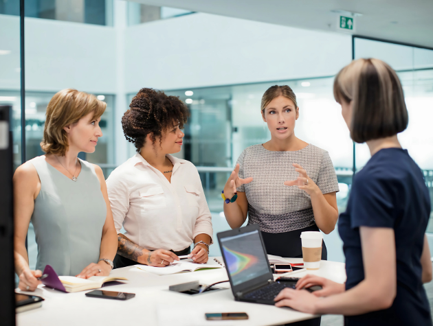 navigating-leadership-in-house-lawyer-women-empowerment A confident female in-house lawyer speaking at a corporate roundtable, symbolizing leadership and empowerment in the legal profession.
