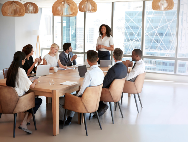 Confident female in-house lawyer leading a team meeting in a modern office setting