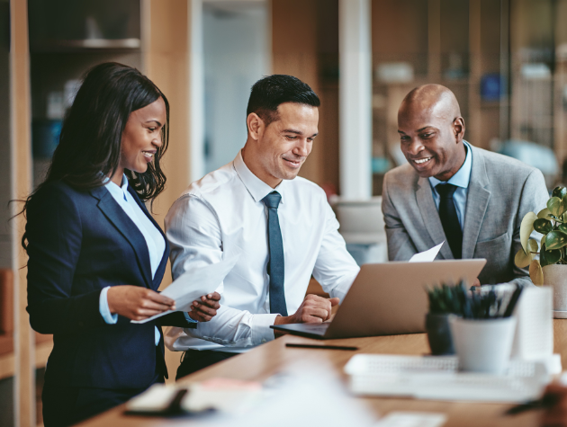 Corporate lawyers collaborating on legal documents at a laptop, symbolizing in-house counsel navigating AI-related risks in IP, privacy, and liability.
