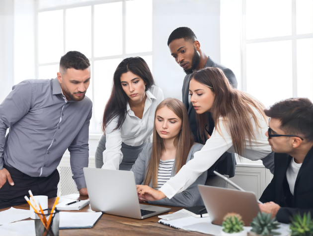 Business team collaborating around a laptop during a strategic planning discussion