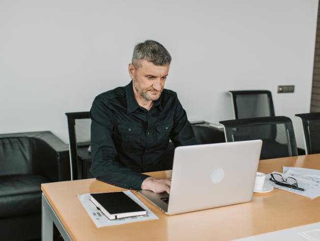 In-house lawyer working at a laptop in a modern office environment