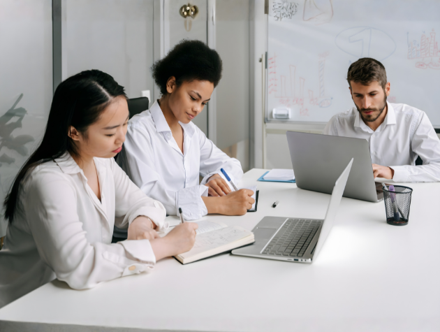 In-house legal professionals collaborating during a mentorship discussion at a conference table
