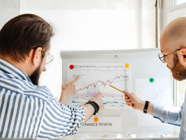 Two professionals reviewing data charts and discussing transparency insights on a whiteboard, symbolizing how in-house counsel assess AI and open-source risks.