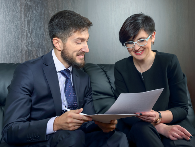 Two legal professionals reviewing documents during a discussion about AI governance and legal risk management